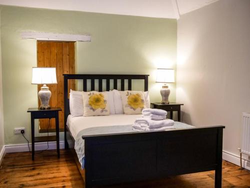 a bedroom with a bed with towels and two lamps at Orchard House - Dingle Town Centre in Dingle