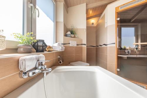 a bathroom with a bath tub and a window at Ferienhaus Stockente in Dagebüll