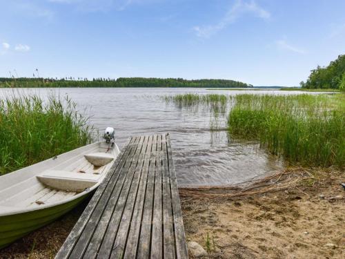 a boat is docked next to a wooden dock at Holiday Home Kuusiranta by Interhome in Harjula