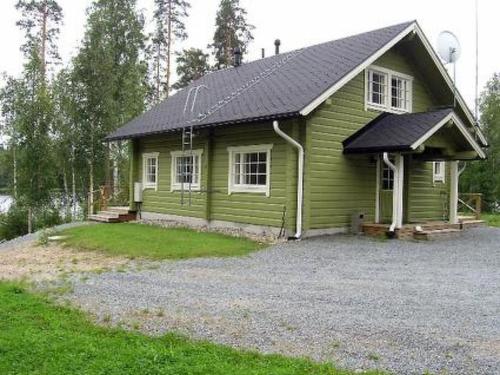 a small green house with a black roof at Holiday Home Villa helmi by Interhome in Holiseva