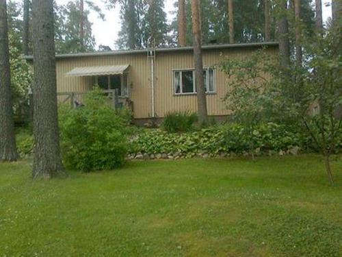 a house in the middle of a yard with trees at Holiday Home Simola by Interhome in Nimimäki