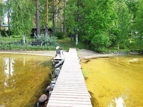 a wooden bridge over a body of water at Holiday Home Simola by Interhome in Nimimäki