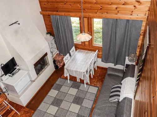 a living room with a table and a fireplace at Holiday Home Lupposyöte b1 by Interhome in Syöte