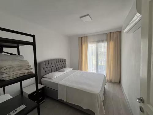 a white bedroom with a bed and a window at Maia Suites in Çeşme