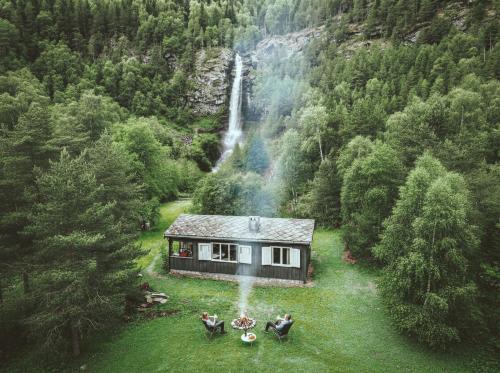 a house in the middle of a forest with a waterfall at Waterfall Retreat in Kolo