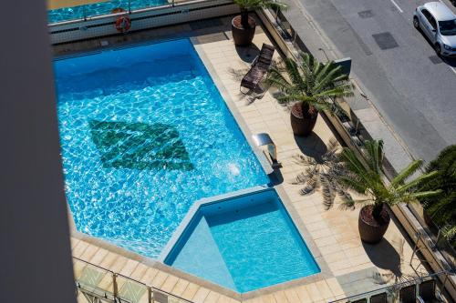 an overhead view of a swimming pool with palm trees at Alven Hotel by Slaviero Hotéis in Joinville