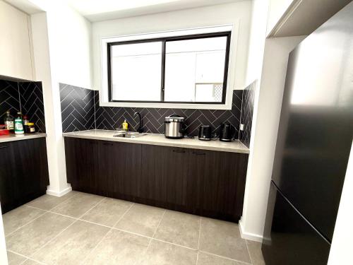 a kitchen with a sink and a window at The Calypso Bay in Jacobs Well