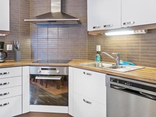 a kitchen with white cabinets and a sink at Holiday Home Villa sofia by Interhome in Vuokatti