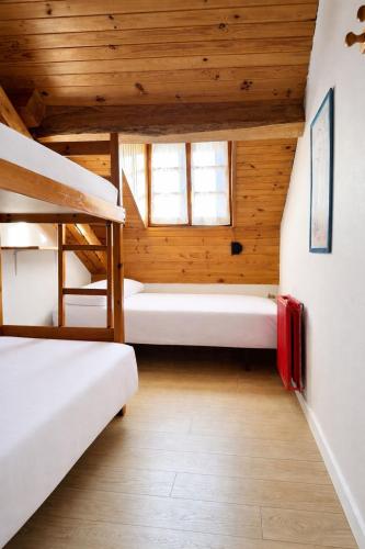a room with two bunk beds and a staircase at Albergue Pájaro L in Castejón de Sos