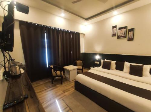 a hotel room with a bed and a desk at Surwel Hotel and Resort in Mussoorie