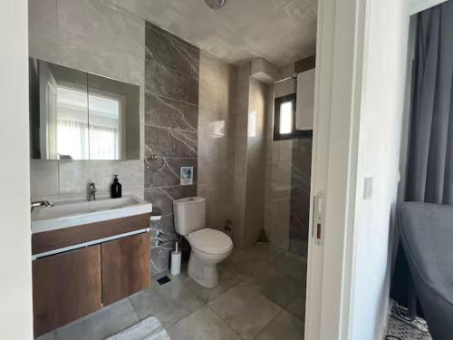a bathroom with a toilet and a sink and a shower at Maia Suites in Çeşme
