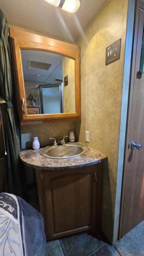 a bathroom with a sink and a mirror at Starry Skies RV in Victoria