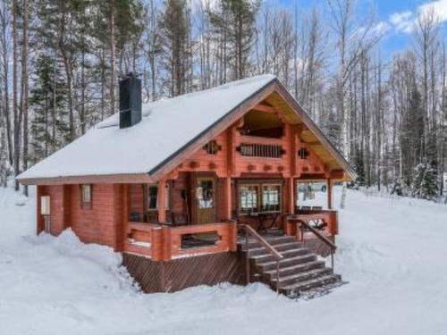a large wooden cabin in the snow with snow at Holiday Home Ahonranta by Interhome in Juntusranta