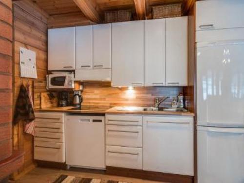 a kitchen with white cabinets and a refrigerator at Holiday Home Ahonranta by Interhome in Juntusranta