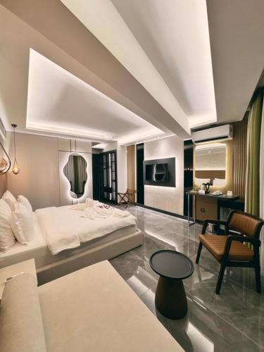 a bedroom with a white bed and a desk at Alberello Otel in Kütahya