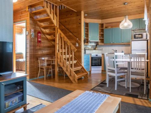a kitchen and dining room with a spiral staircase in a log cabin at Holiday Home Noukatti by Interhome in Lahdenperä