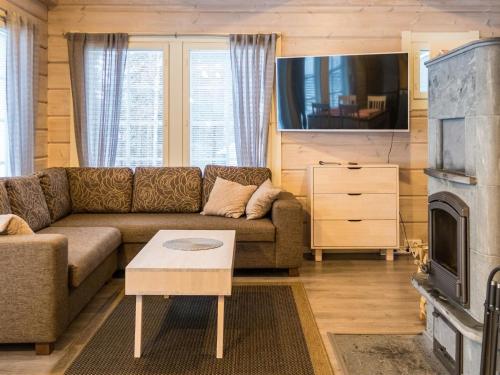 a living room with a couch and a fireplace at Holiday Home Leimu a by Interhome in Vuokatti