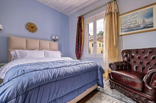 a bedroom with a bed and a leather chair at Theodoros Kolokotronis in Nafplio