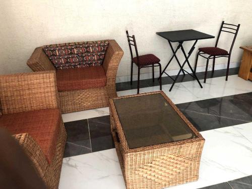 un gruppo di sedie di vimini e un tavolo in una stanza di Appartement Studio Privilège VIP a Palimé