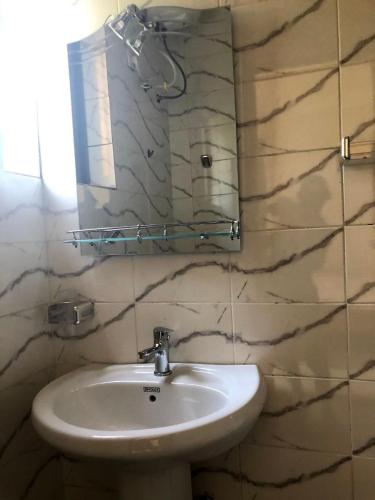 un bagno con lavandino e specchio di Appartement Studio Privilège VIP a Palimé