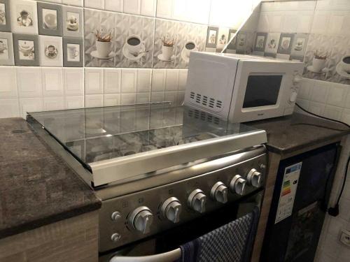 una cucina con forno a microonde e piano di lavoro di Appartement Studio Privilège VIP a Palimé