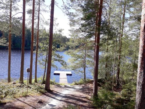 a bench in the woods next to a lake at Holiday Home Aili by Interhome in Arrakoski