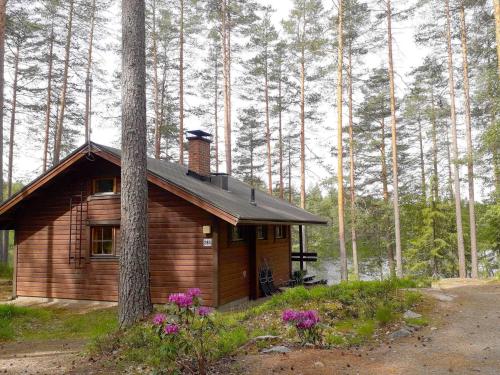 a small wooden cabin in the middle of a forest at Holiday Home Aili by Interhome in Arrakoski