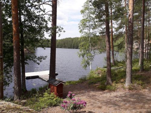 a dock in the middle of a lake with trees at Holiday Home Aaretti by Interhome in Arrakoski