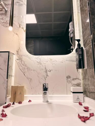a bathroom sink with a soap dispenser and a mirror at Alberello Otel in Kütahya