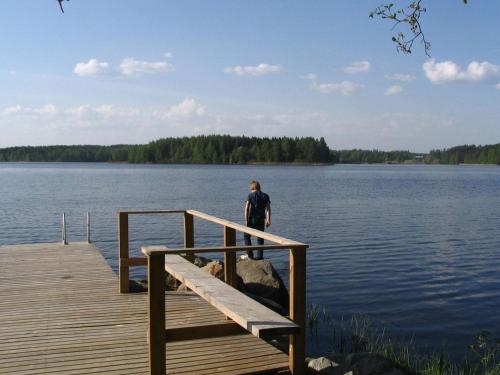 a person standing on a dock on a lake at Holiday Home Tervaleppä by Interhome in Torvoila