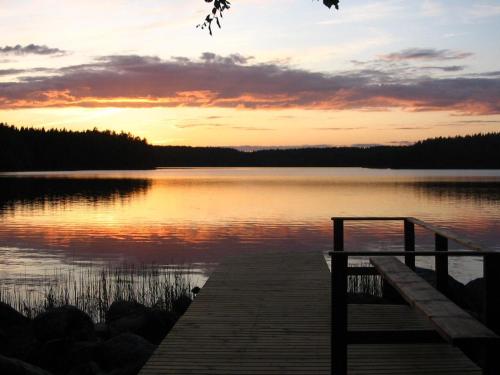 a sunset over a lake with a wooden dock at Holiday Home Tervaleppä by Interhome in Torvoila