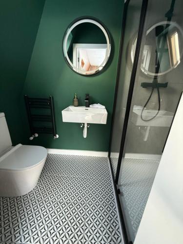 a green bathroom with a sink and a mirror at Elis Village in Sadova