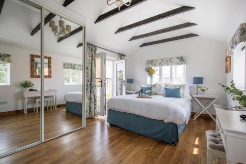 a bedroom with a bed and a mirror at The Boathouse in Waldringfield