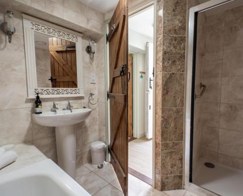 a bathroom with a tub and a sink and a shower at The Boathouse in Waldringfield