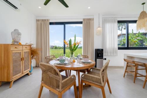 a dining room with a wooden table and chairs at Villa Sawahku - 2BR Private Villa with Rooftop & Rice Field View in Canggu