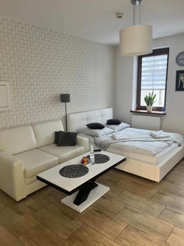 a living room with a couch and a bed and a table at Apartamenty AP 1 in Częstochowa