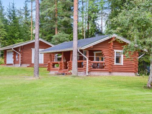 a log cabin in the woods with a yard at Holiday Home Kivitasku by Interhome in Kallionkieli
