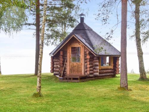 a log cabin in a field with trees at Holiday Home Kivitasku by Interhome in Kallionkieli
