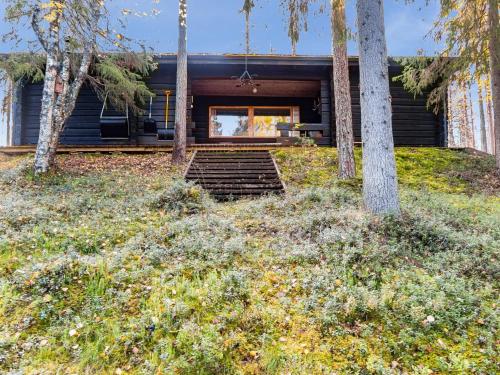 a house in the woods with trees and grass at Holiday Home Miilumaja by Interhome in Äkäslompolo