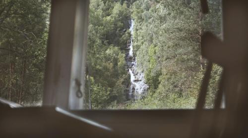 a view of a waterfall from a window at Waterfall Retreat in Kolo