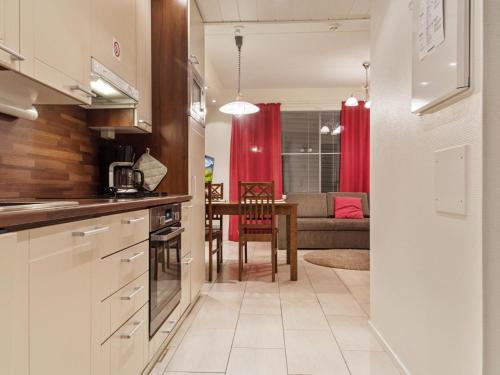 a kitchen and living room with a table and a couch at Holiday Home Yllästar 3 as 609 by Interhome in Äkäslompolo