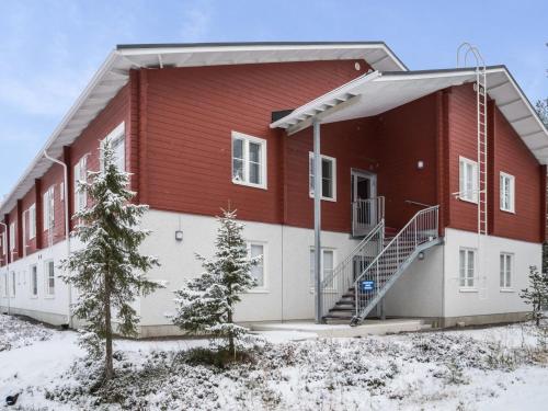 a red and white building with snow on the ground at Holiday Home Yllästar 3 as 609 by Interhome in Äkäslompolo