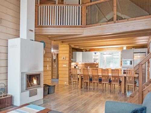 a living room with a fireplace and a table and chairs at Holiday Home Sopukka by Interhome in Vuokatti