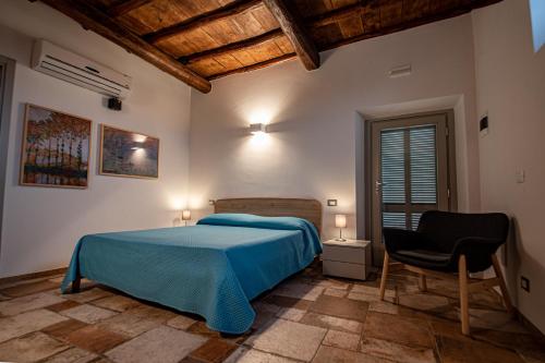 a bedroom with a blue bed and a chair at Agriturismo I Due Casali in Vetralla