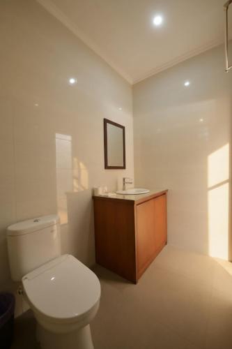 a bathroom with a white toilet and a sink at Kubu Daje - Comfortable New Villa in Canggu in Dalung