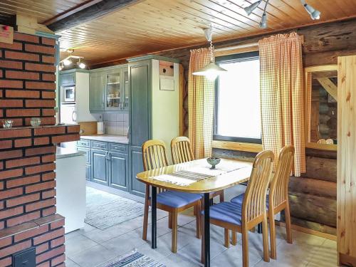 a kitchen with a wooden table and chairs in a room at Holiday Home Jäkälä by Interhome in Kyrö