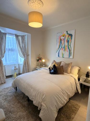 a bedroom with a large white bed with a large window at 2 bed apartment close to beach in Herne Bay