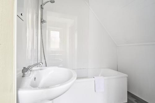 a white bathroom with a sink and a tub at Suggitt House in Hartlepool
