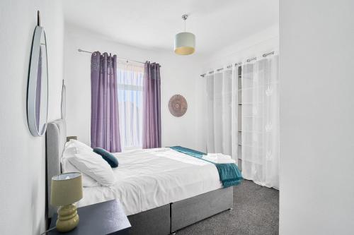 a white bedroom with a bed and a window at Suggitt House in Hartlepool