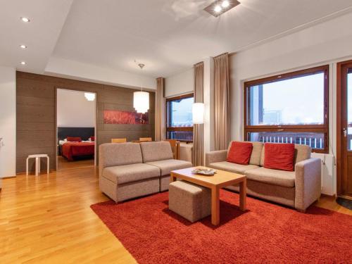 a living room with two couches and a table at Holiday Home Ski chalets 6405 by Interhome in Ylläsjärvi